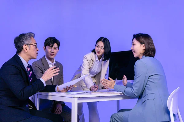 アジアの韓国人シニア 中年男性と若い男性と女性の同僚モデルのビジネス服装 ネオン紫のスタジオの背景 会議のコンセプト — ストック写真