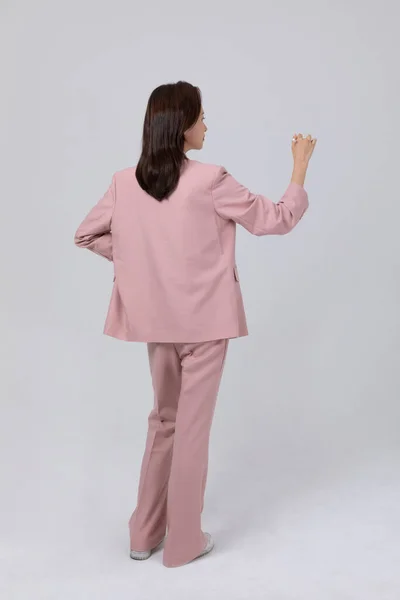stock image business concept korean young woman, standing with holding a pen. studio shot