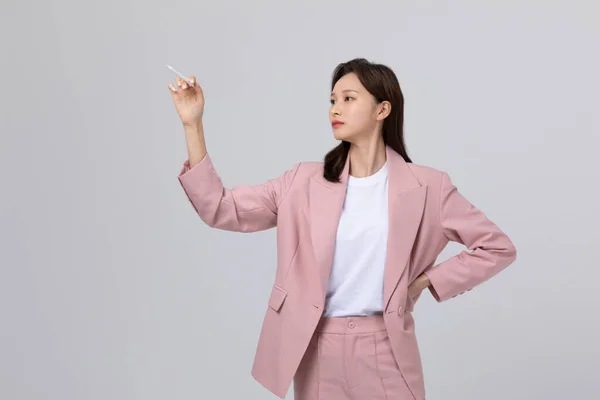 Koreli Genç Bir Kadın Elinde Kalem Tutarak Anlatıyor Stüdyo Çekimi — Stok fotoğraf