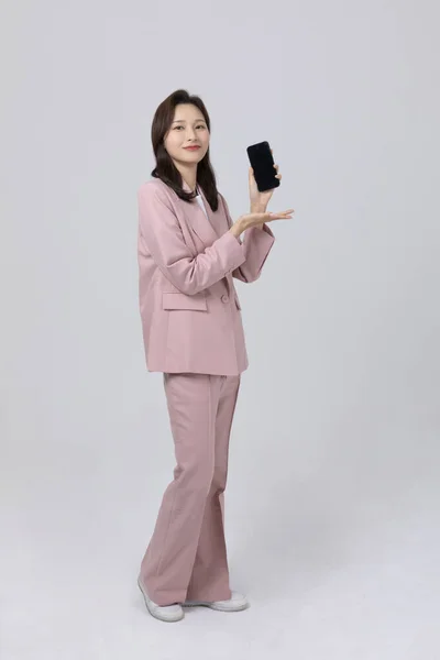 ビジネスコンセプト韓国人の若い女性がスマートフォンを持っています スタジオショット — ストック写真