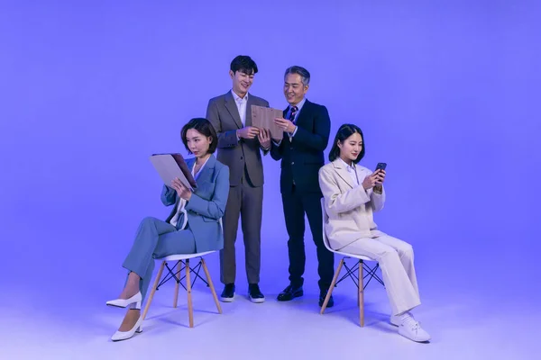 亚裔韩国老年人 中年人和年轻男女同事在商务服装 霓虹灯紫色工作室背景 工作理念等方面的典范 — 图库照片