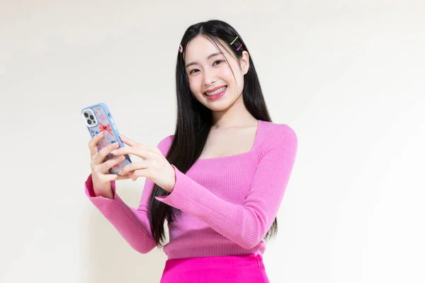 ヴィンテージY2Kピンクレトロのコンセプト写真韓国のアジアのかわいい女性がスタジオの背景にスマートフォンを持って — ストック写真