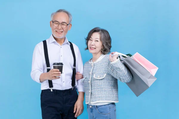 Aktives Junges Koreanisches Paar Mit Einkaufstaschen Und Kaffee Vor Studiohintergrund — Stockfoto