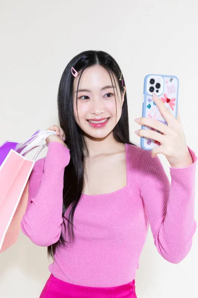 古色古香的Y2K粉红复古的概念照片韩国亚洲可爱的女人拿着智能手机和购物袋 — 图库照片