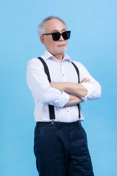 active young senior Korean Asian male wearing sunglasses against studio background