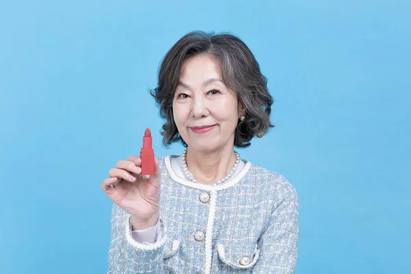 持有口红的活跃的年轻的资深韩裔亚洲妇女 — 图库照片