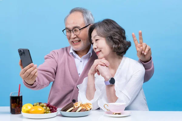active young senior korean asian couple taking selfies