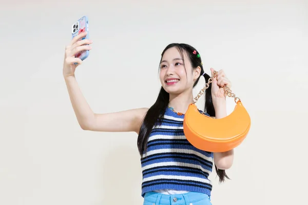 ヴィンテージY2Kピンクレトロのコンセプト写真韓国のアジアのかわいい女性がスタジオの背景にバッグやスマートフォンを保持 — ストック写真