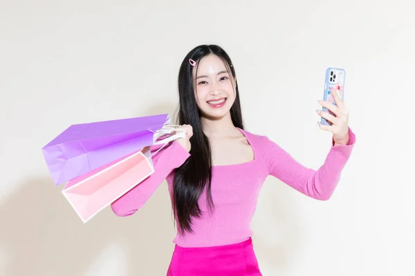 ヴィンテージY2Kピンクレトロなコンセプト写真韓国人可愛いアジア人女性がスマホやショッピングバッグを持っている — ストック写真