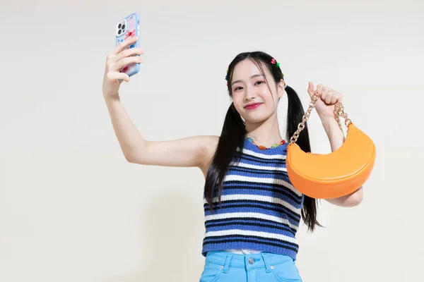ヴィンテージY2Kピンクレトロのコンセプト写真韓国のアジアのかわいい女性がスタジオの背景にバッグやスマートフォンを保持 — ストック写真
