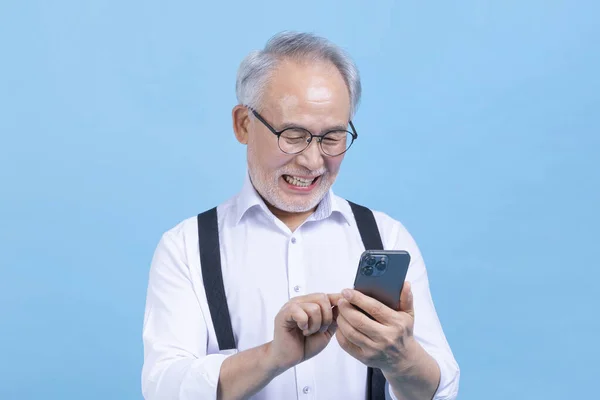 Молодий Старший Корейський Чоловік Який Дивиться Смартфон Проти Студійного Фону — стокове фото