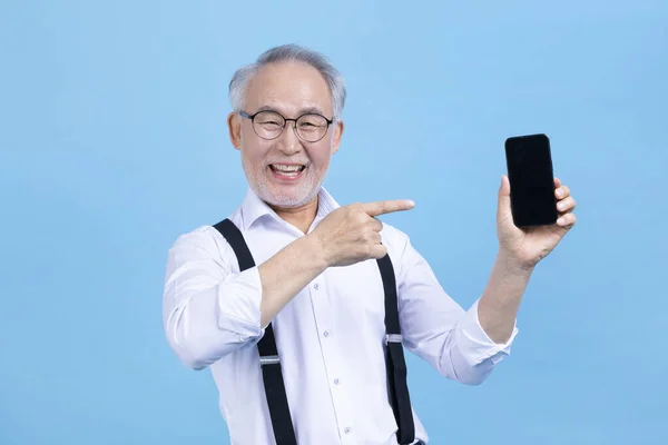 Stüdyo Geçmişine Karşı Kulaklık Takan Yaşlı Yaşlı Koreli Bir Erkek — Stok fotoğraf
