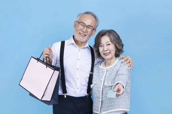Aktif Genç Koreli Yaşlı Çift Ellerinde Alışveriş Torbaları Kredi Kartı — Stok fotoğraf
