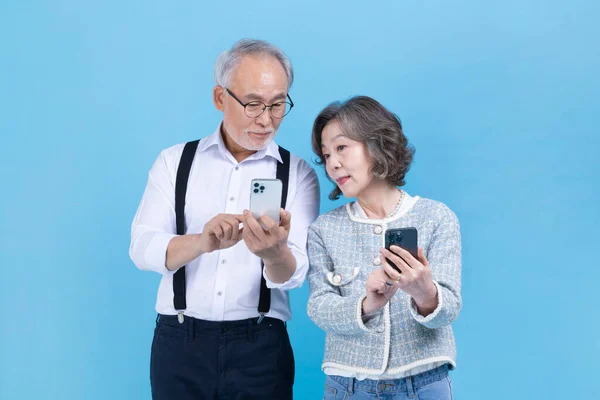 Aktivt Eldre Koreansk Asiatisk Par Som Ser Smarttelefon – stockfoto