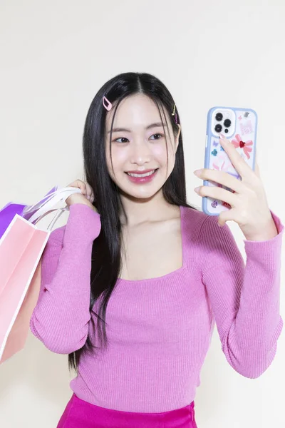 古色古香的Y2K粉红复古的概念照片韩国亚洲可爱的女人拿着智能手机和购物袋 — 图库照片
