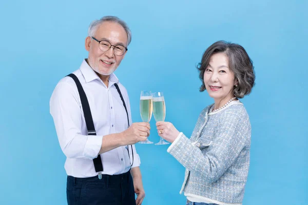手持香槟酒杯的活跃的资深韩裔老年夫妇 — 图库照片