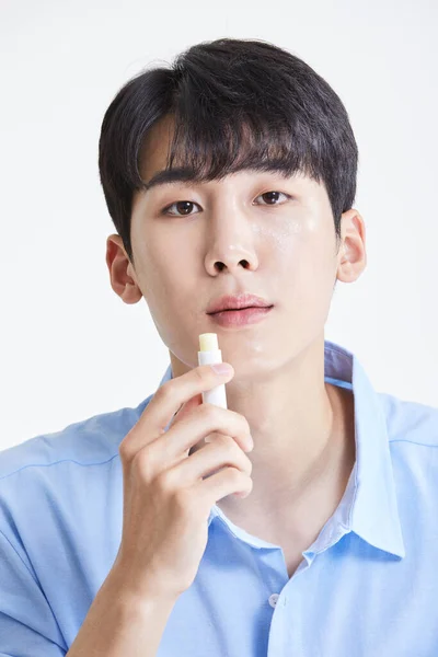 Coreano Asiático Joven Hombre Aplicando Labio Bálsamo —  Fotos de Stock