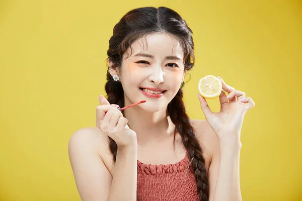 韩国美丽女人拿着唇膏和柠檬的美感照片 — 图库照片