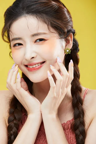 韩国女人在触摸脸 工作室背景时面带微笑的美感照片 — 图库照片