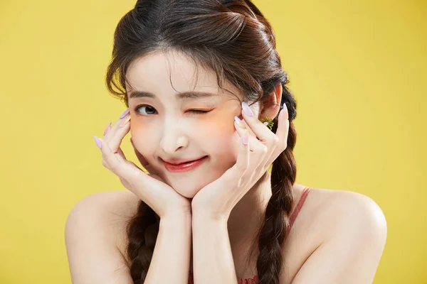韩国美丽女人的美丽概念照片 她的下巴靠在手上 并提供了一个眨眼 工作室背景 — 图库照片
