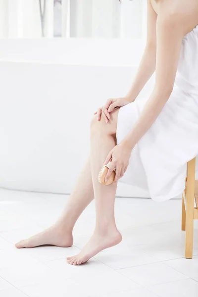 彼女の足をスクラブするためにブラシを使用して韓国の朝鮮の美しい女性の美容コンセプトの写真 — ストック写真