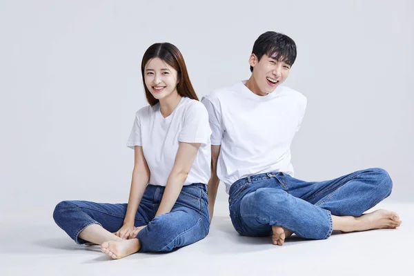 Korean Asian Young Couple Sitting Cross Legged Studio Background — Stock Photo, Image