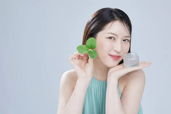 portrait asian woman with natural makeup presenting beauty product