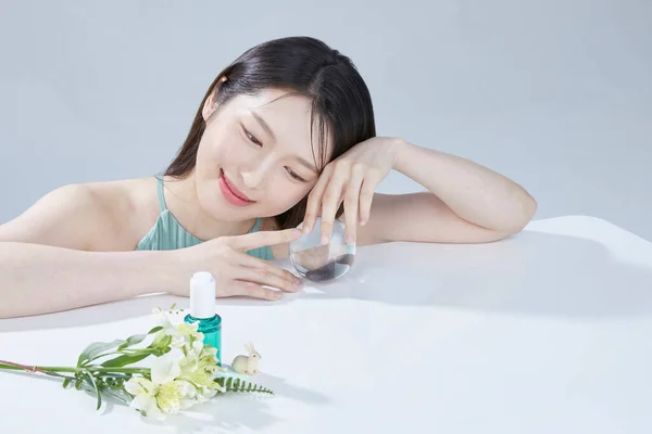 portrait asian woman with natural makeup presenting beauty product