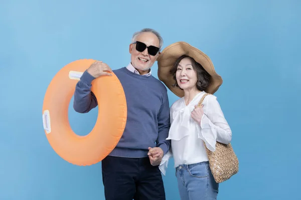 A middle aged man with a tube and a middle aged woman with a wide brim hat