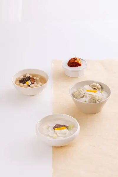 Three Bowls Rice Cake Soup Kimchi Placed White Table Covered — Stock Photo, Image