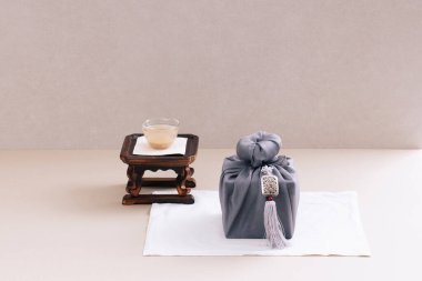 There is sikhye on the tea table and a gift cloth next to it clipart