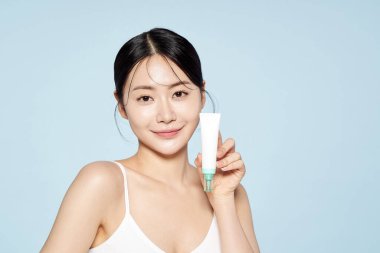 Asian Woman Poses With White Eye Cream clipart