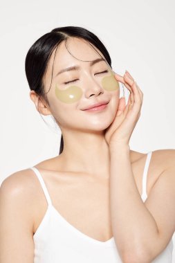 Asian woman posing with eye patches on both cheeks clipart