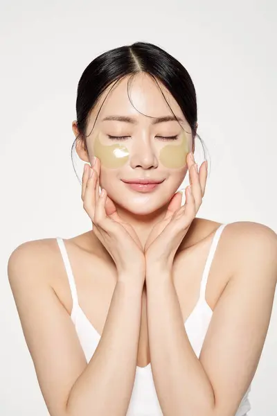 Stock image Asian woman with eye patches on both cheeks and gently closed her eyes