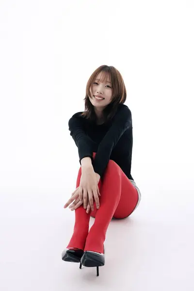 stock image Korean Woman Sitting and Posing on the Floor in Red Leggings