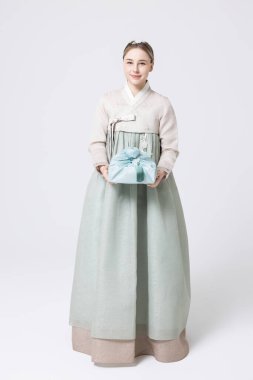 Western woman wearing Hanbok and holding a gift wrapped in Korean style clipart