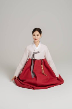 A woman in her 20s bowing while wearing a hanbok clipart