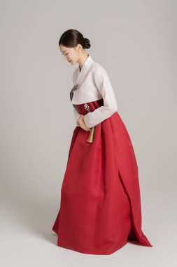 A woman in her 20s wearing a hanbok and greeting you in a polite manner clipart