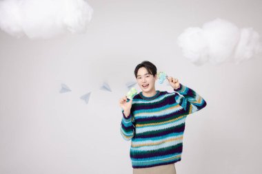 Portrait of a man standing in the clouds holding candy clipart