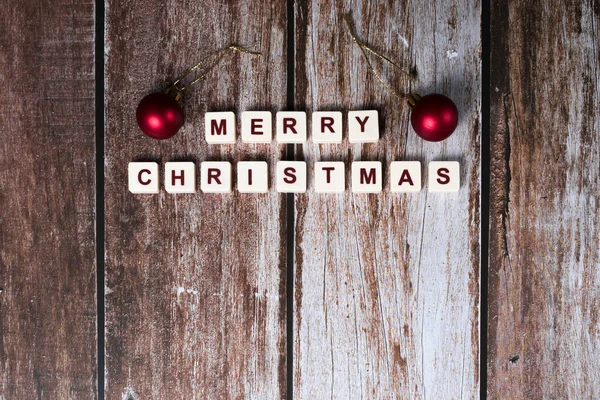 stock image Merry Christmas written with letters of a game and Christmas ornaments on a wooden background