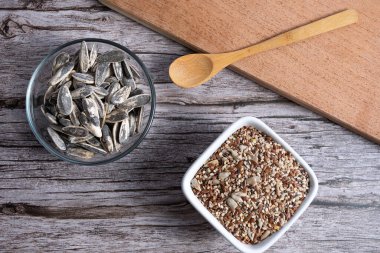 Tahtanın üst görüntüsü, ayçiçeği tohumlu kase ve tohum karışımlı kase.