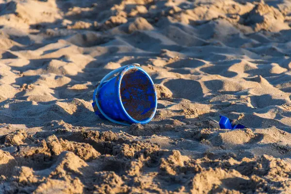 在沙滩上的沙地上 蓝色塑料玩具做成的刀片非常脏 — 图库照片