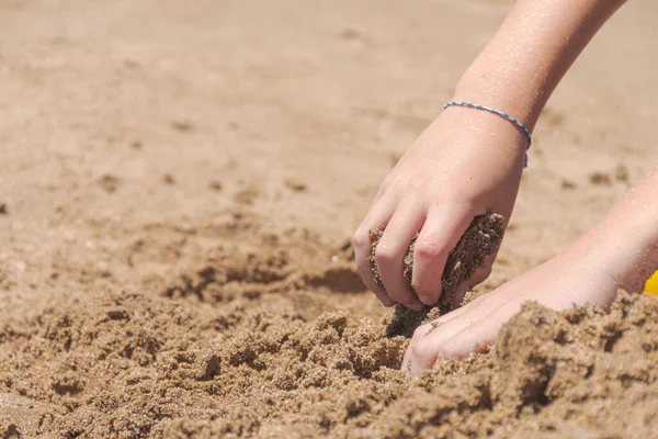 海滩上玩沙子的孩子的手 — 图库照片