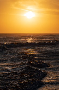 Denizde gün batımı Bulutlar tarafından karartılmış güneşle.