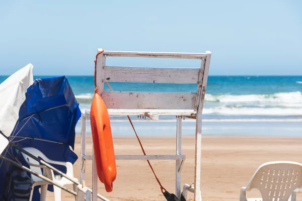 stock image Empty lifeguard station on the beach with chair and umbrella.