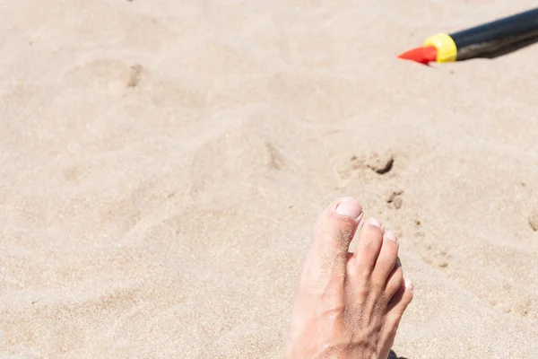 人类脚踏在沙滩上的选择性焦点 背景是塑料器皿 度假放松的概念 — 图库照片