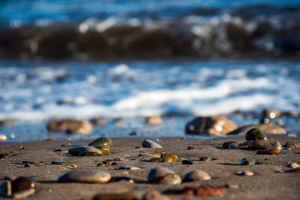 Foco Seletivo Areia Pedras Uma Praia Com Quebra Mar Fundo — Fotografia de Stock