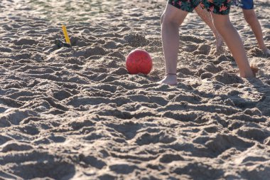 Çocukların ayakları sahilde futbol oynuyor..