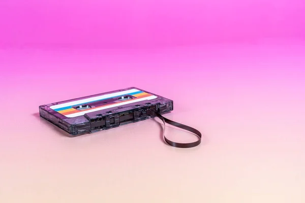 ラベルおよび出力テープが付いている透明なオーディオ カセット Fuchsiaの背景 — ストック写真