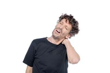 Orta yaşlı bir adam, beyaz arka planda, kederli bir ifadeyle boynunu tutuyor..